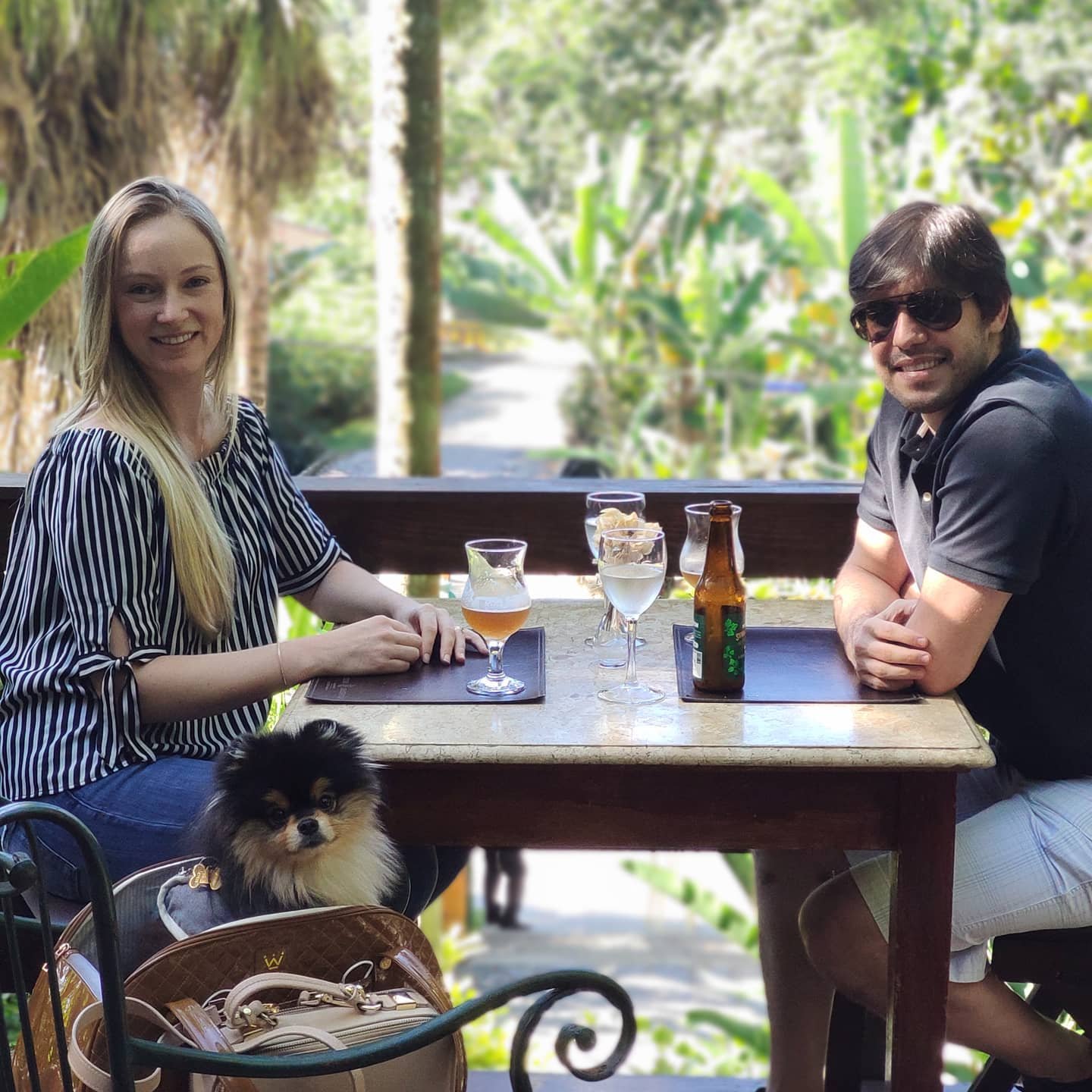 Casal com seu cachorro no deck do Jardim Secreto